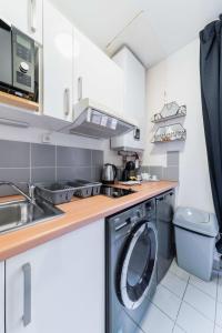 a small kitchen with a washer and dryer at Studio cosy vue sur le musée - Paris 5 - 2P in Paris