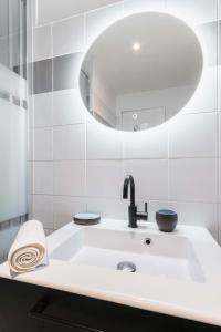 a white bathroom with a sink and a mirror at Studio cosy vue sur le musée - Paris 5 - 2P in Paris