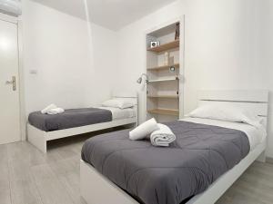 2 camas en una habitación con paredes blancas en Paloma center town apartment en Bellagio