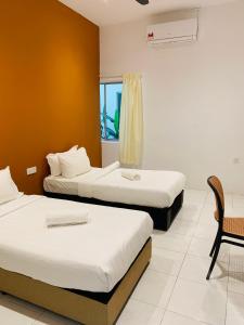 a hotel room with two beds and a chair at LiLLA Rainforest Retreats by Swing & Pillows in Hulu Langat