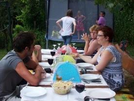 un grupo de personas sentadas en una mesa de picnic en Aranyos Ég en Ibafa