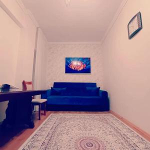 sala de estar con sofá azul y piano en Altyn-Adam Hotel, en Astana