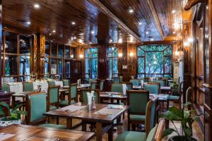 un restaurant avec des murs en bois, des tables et des chaises dans l'établissement Pierre Hotel, à Siem Reap