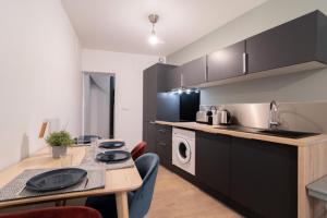 uma cozinha e sala de jantar com uma mesa e um lavatório em Lille Centre: 2bed 2bath apartment! em Lille