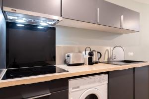 uma cozinha com fogão forno ao lado de um lavatório em Lille Centre: 2bed 2bath apartment! em Lille