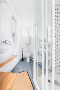 a bathroom with a toilet and a glass door at Agréable studio cœur de paris - Paris 6 - 2P in Paris