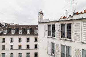 un groupe de bâtiments aux fenêtres et aux toits blancs dans l'établissement Agréable studio cœur de paris - Paris 6 - 2P, à Paris