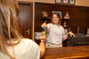 eine Frau steht vor einem Spiegel und hält eine Zahnbürste in der Unterkunft Galeria Holiday Apartments in Obsor + 34 Fotos