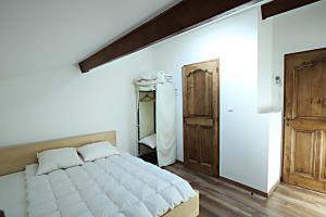 a bedroom with a large white bed and wooden floors at LOUSTERAPH in Saint-Rémy-de-Provence