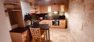 a small kitchen with a black counter top and wooden cabinets at LOUSTERAPH in Saint-Rémy-de-Provence