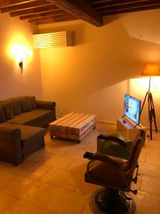 a living room with a couch and a chair at LOUSTERAPH in Saint-Rémy-de-Provence