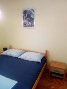 Un dormitorio con una cama azul y una foto en la pared en Luka, en Split