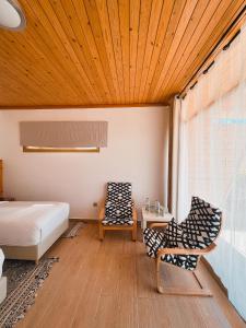 1 Schlafzimmer mit einem Bett und 2 Stühlen in der Unterkunft Hotel Dakhla Club in Ad-Dakhla