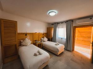 a hotel room with two beds and a window at Hotel Dakhla Club in Dakhla