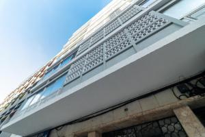 Ein weißes Gebäude mit einem Zaun an der Seite. in der Unterkunft Universo Apartamento in Lissabon