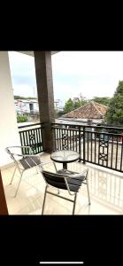 eine Terrasse mit einem Tisch und Stühlen auf dem Balkon in der Unterkunft cozy house in pekayon, bekasi in Pekayon Satu