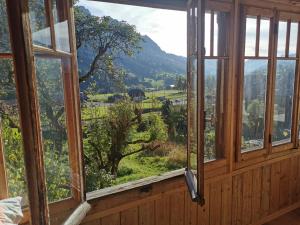 a window with a view of a mountain at Nouveau à Rougemont: Appartement dans Chalet 1830 in Rougemont