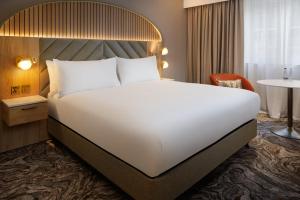 a large white bed in a hotel room at DoubleTree by Hilton Bristol North in Bristol