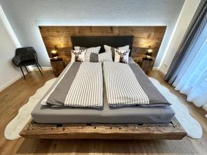 a bedroom with a large bed with a wooden headboard at Ferienwohnung BERGSEERUHE - Allgäu - Wandern - Relaxen in Sulzberg