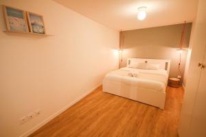 a bedroom with a white bed and a wooden floor at Lille Grand Place - Apartment With 2 Bedrooms in Lille