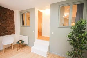 a living room with a staircase and a white chair at Lille Grand Place - Apartment With 2 Bedrooms in Lille