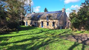 une ancienne maison en pierre sur une pelouse dans l'établissement 3 chambres dans typique longère en pierre bretonne, à Tresboeuf