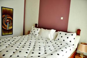 1 cama blanca en un dormitorio con una pintura en la pared en VILLA MODERNE CHEZ YVONNE en Kigali