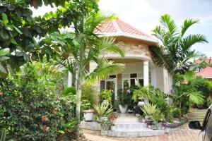 a small white house with palm trees in front of it at VILLA MODERNE CHEZ YVONNE in Kigali