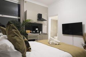 a bedroom with a bed with a flat screen tv at Stylish Studio Apartments, Willesden in London