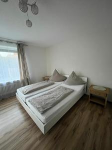 a white bedroom with a bed and a window at Ferienwohnung am Chiemsee in Bernau am Chiemsee