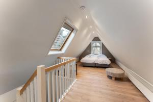 a attic room with a bed and a staircase at Brugse charme huis met tuin aan het water 8p in Bruges