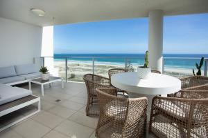 un soggiorno con tavolo, sedie e vista sull'oceano di Villa Sol - Luxury 3 Bedroom Villa in Kirra a Gold Coast