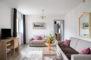 a living room with a couch and a table at Hôtel Vauban Briançon Serre Chevalier in Briançon