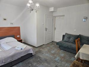 1 dormitorio con cama, sofá y mesa en Zajazd nad Wisłą, en Dobrzyków