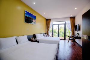 um quarto de hotel com duas camas e uma varanda em My's Flower Villa em Hoi An