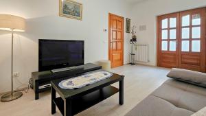 uma sala de estar com uma televisão e uma mesa de centro em Zigante em Novigrad Istria