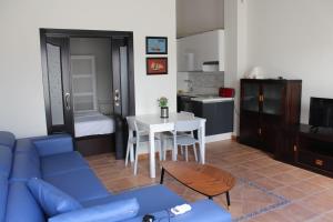 ein Wohnzimmer mit einem blauen Sofa und einer Küche in der Unterkunft CASA TABARCA in Tabarca