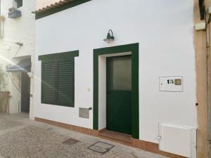 eine grüne Tür an der Seite eines Gebäudes in der Unterkunft CASA TABARCA in Tabarca