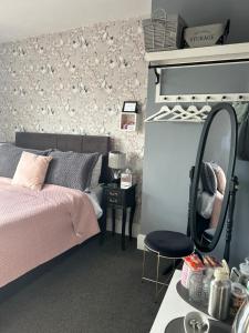 1 dormitorio con cama, espejo y silla en Cherwood Guest House en Paignton