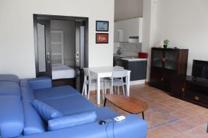 ein Wohnzimmer mit einer blauen Couch und eine Küche in der Unterkunft CASA TABARCA , disfruta del mágico atardecer de la isla in Tabarca