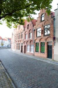 a cobblestone street in front of brick buildings at Brugse charme huis met tuin aan het water 8p in Bruges