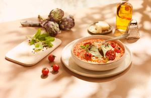 uma tigela de comida numa mesa com tomates e queijo em Campanile Annecy - Cran Gevrier em Annecy