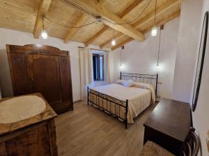 um quarto com uma cama e um tecto de madeira em CASA RO em Salaiola