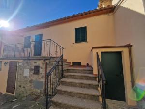 uma escada que conduz a um edifício com uma porta verde em CASA RO em Salaiola