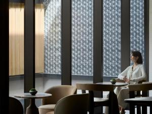 a woman sitting at a table in a restaurant at Dusit Thani Kyoto in Kyoto