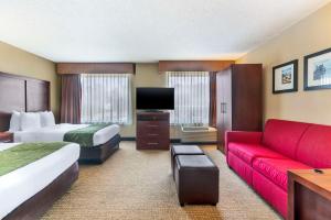 a hotel room with two beds and a couch at Comfort Suites Wilmington near Downtown in Wilmington