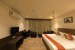 una camera d'albergo con letto e TV di The Byke Suraj Club, Junagadh a Junagadh