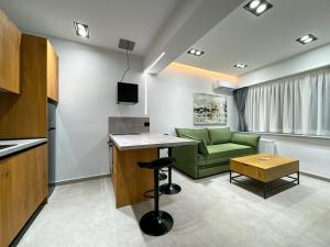 a living room with a green couch and a table at GreenKaravan Suite in Thessaloniki