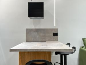 a kitchen with a counter with a tv on the wall at GreenKaravan Suite in Thessaloniki