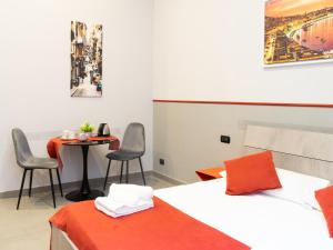 ナポリにあるB&B Core Napoliのベッドルーム1室(ベッド1台、テーブル、椅子付)